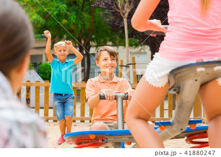 Cheerful children are teetering on the swing Cheerful children are teetering on the swing 41880247