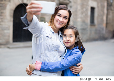 Smiling mother and daughter taking photo Smiling mother and daughter taking photo 41881385