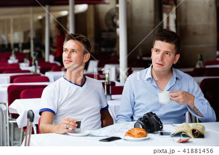 Couple of male tourists talking and drinking coffee 41881456