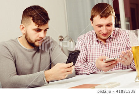 Two men with smartphones at home Two men with smartphones at home 41881538