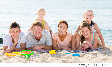 Parents with children lying on sand Parents with children lying on sand 41881757