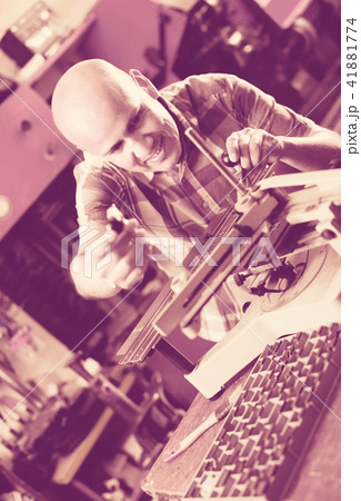 Workman making mailbox plate in workshop. 41881774