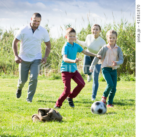 Cheerful parents with two kids playing soccer 41881870