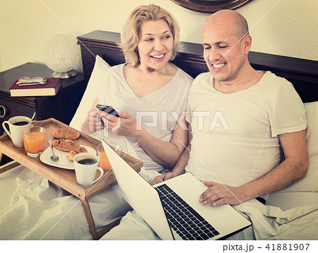 Mature smiling couple reading news from notebook Mature smiling couple reading news from notebook 41881907