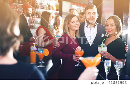 Man with female friends in bar 41881998