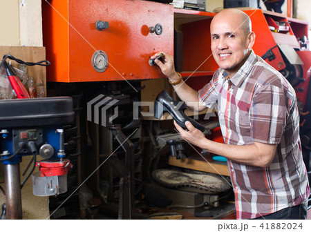 Workman repairing pair of shoes . Workman repairing pair of shoes . 41882024