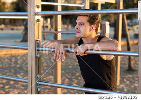 Sporty man near outdoor wall bars 41882105