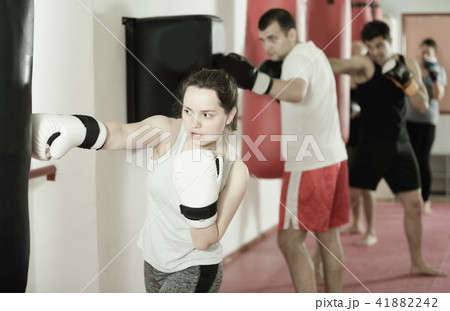 Young athlete female is beating a boxing bag 41882242