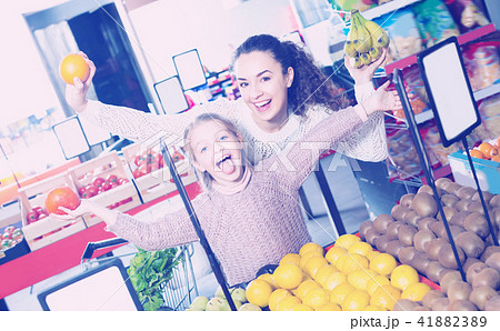 Laughing mother and daughter buying fruits Laughing mother and daughter buying fruits 41882389
