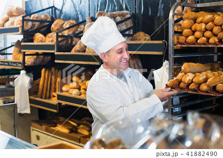 Portrait of senior man staff working with fresh baguettes 41882490