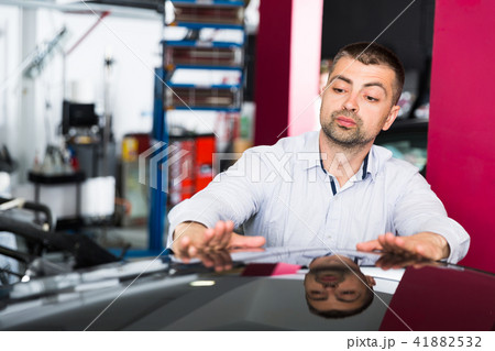 Male client inspecting painting quality of vehicle Male client inspecting painting quality of vehicle 41882532