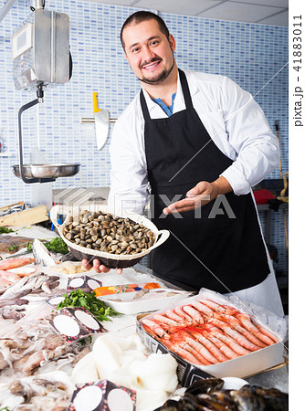 Man holds small basket of mussels 41883011