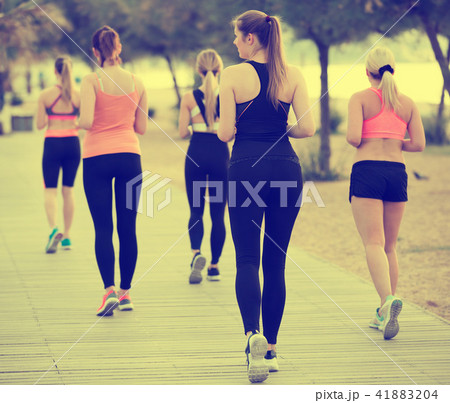 Women running along embankment in sunny morning Women running along embankment in sunny morning 41883204