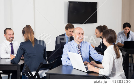 Group of colleagues with laptops having a productive day 41883250