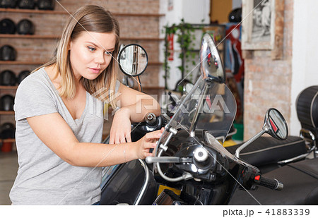 Woman is shopping and choosing new motobike 41883339