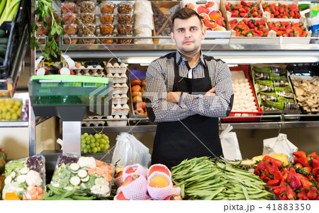 male seller showing assortment of grocery shop 41883350