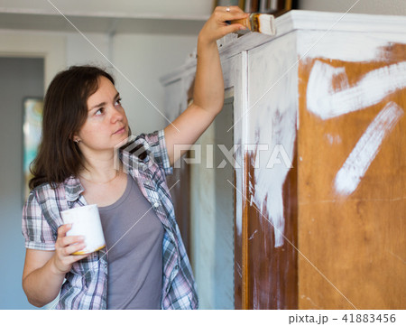 Smiling woman paints closet at home during repairs 41883456