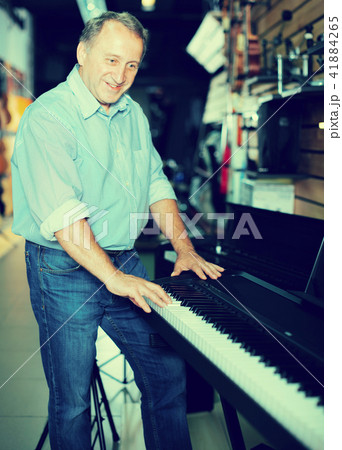 Musician male is choosing keyboard and playing on it 41884265