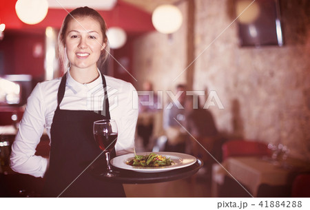 Portrait of smiling waitress with serving tray meeting restauran 41884288