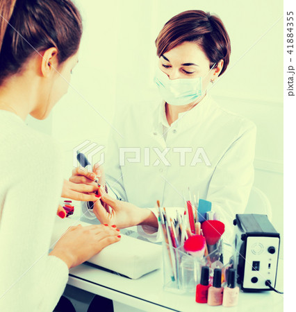 Female client doing nails in shellac technique 41884355