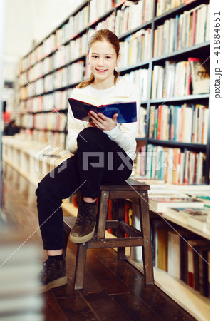 Girl reading book in bookshop Girl reading book in bookshop 41884651