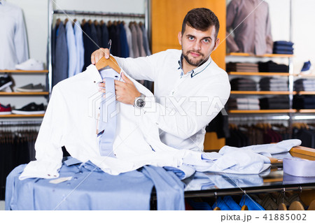 Portrait of male shopping assistant showing shirt 41885002