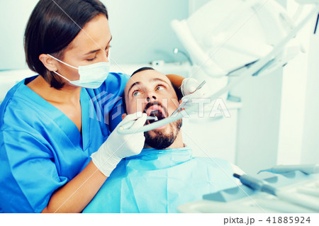 Stomatologist girl in uniform is taking visional inspection of a man 41885924