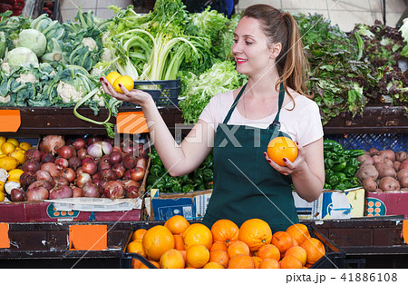 seller woman is demonstraiting oranges 41886108