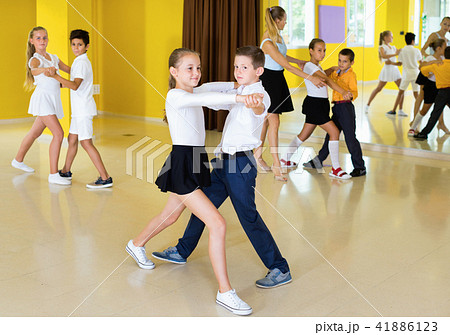 Little boys and girls having dancing class in classroom Little boys and girls having dancing class in classroom 41886123