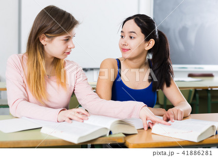 Smiling schoolgirls are learning at the desk Smiling schoolgirls are learning at the desk 41886281