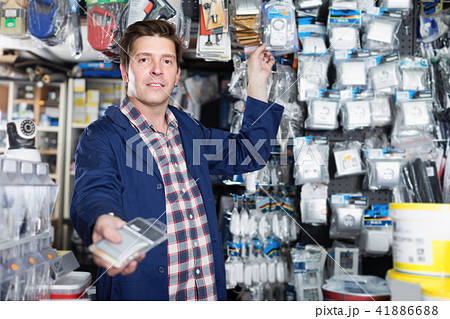 Seller demonstrating plastic sockets in the store Seller demonstrating plastic sockets in the store 41886688