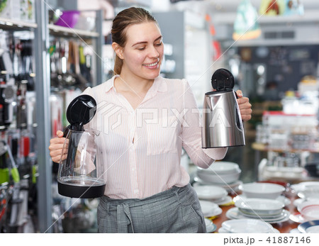 Woman housewife looking electric kettle in kitchen appliances section Woman housewife looking electric kettle in kitchen appliances section 41887146