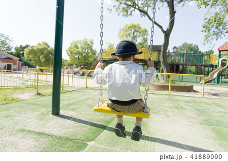 A kindergarten child playing with a swing in a par 41889090