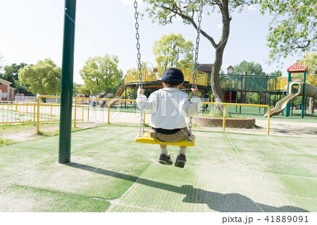 A kindergarten child playing with a swing in a par 41889091