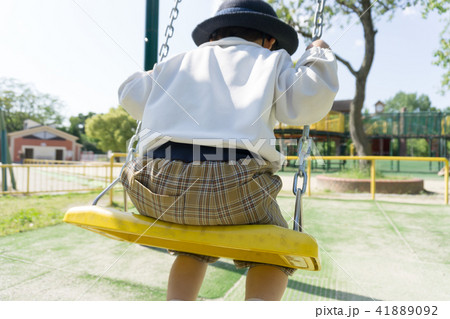 A kindergarten child playing with a swing in a par 41889092