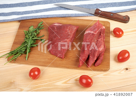 Raw Beef Meat On Cutting Board With Vegetables On A Wooden Background Stock  Photo, Picture and Royalty Free Image. Image 105018696.