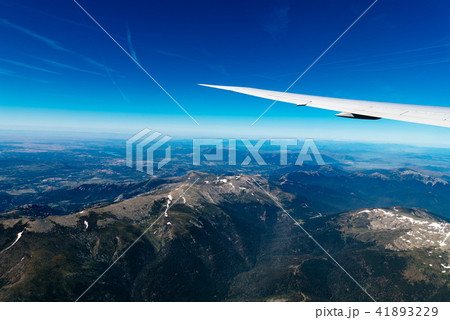 Aerial view of landscape through airplane window against sky Aerial view of landscape through airplane window against sky 41893229