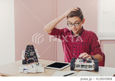 Stem education. Boy creating robot at lab Stem education. Boy creating robot at lab 41904968