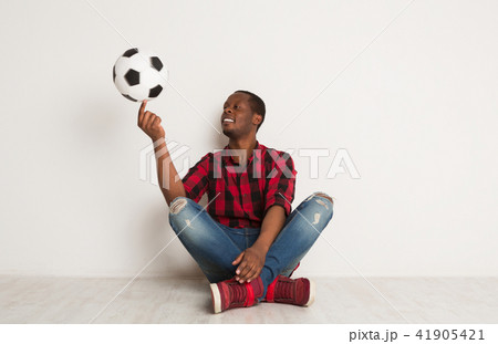 Happy smiling black man spinning ball on his finger Happy smiling black man spinning ball on his finger 41905421