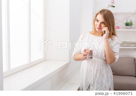 Smiling pregnant woman talking on her smartphone, copy space. 41906071