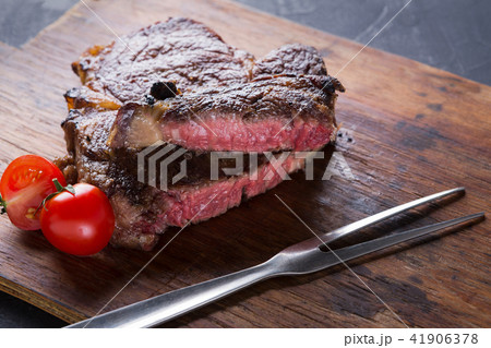 Rare rib eye steak on wooden board, closeup 41906378