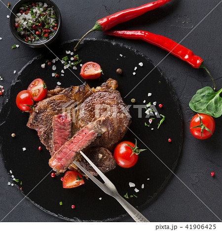 Rare rib eye steak on dark plate, top view 41906425