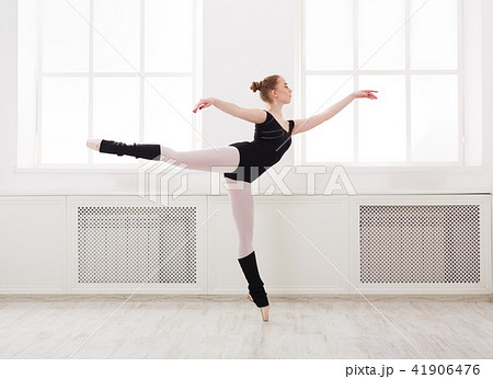 Beautiful ballerina stands in ballet arabesque Beautiful ballerina stands in ballet arabesque 41906476