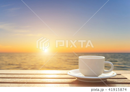 Coffee cup on wood table at sunset or sunrise time 41915874