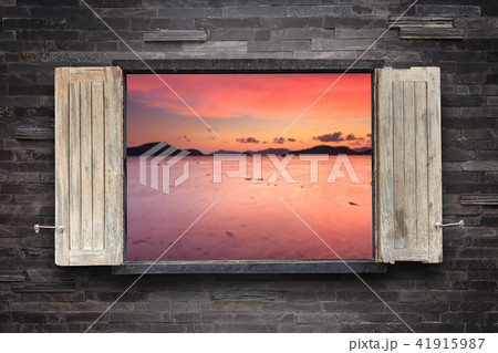 Old wooden windows frame on stone wall and view of the sea 41915987