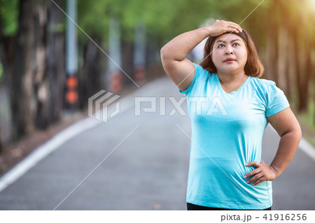 Fat woman feeling tired while running in the park Fat woman feeling tired while running in the park 41916256