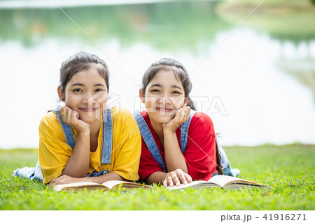 Pretty asian twins girl or students reading a book in the public park 41916271