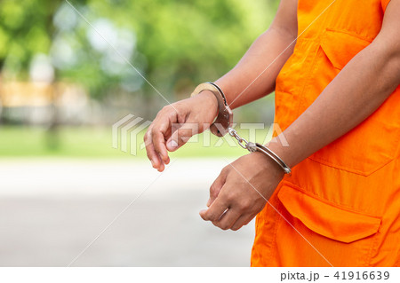 Arms of Thai monk with metal silver handcuff. Arrest the monk or criminal concept 41916639