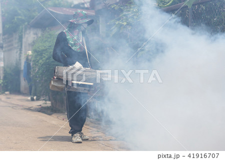 Worker fogging chemical to eliminate mosquito at the street Worker fogging chemical to eliminate mosquito at the street 41916707