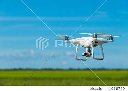 Flying drone quadcopter with digital camera on blue sky Flying drone quadcopter with digital camera on blue sky 41916740